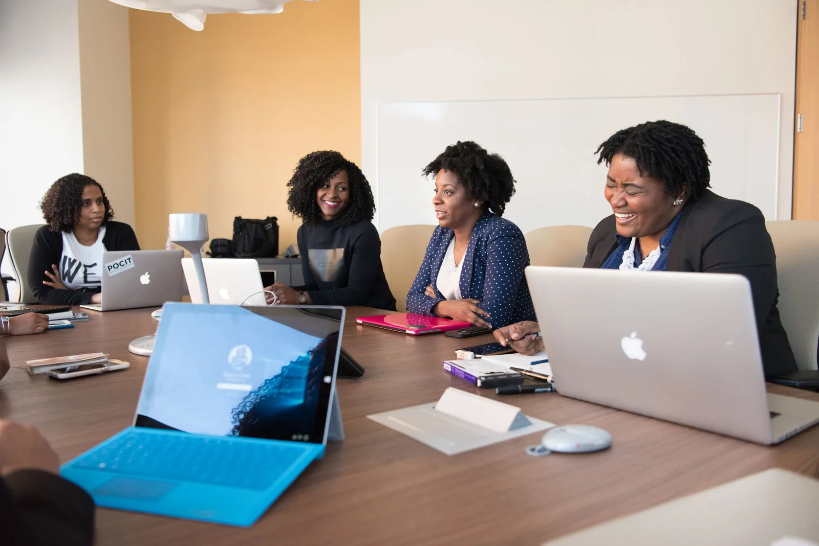 A nonprofit treasurer reviewing donation options on a laptop during a small team meeting