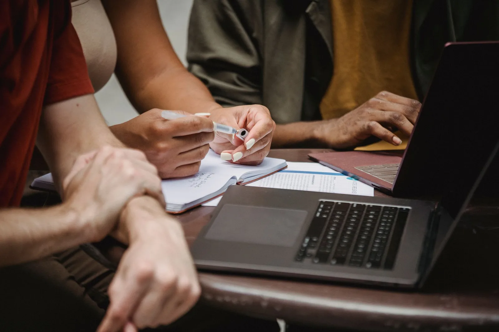 Two nonprofit staff members reviewing a grant draft on a laptop at a table