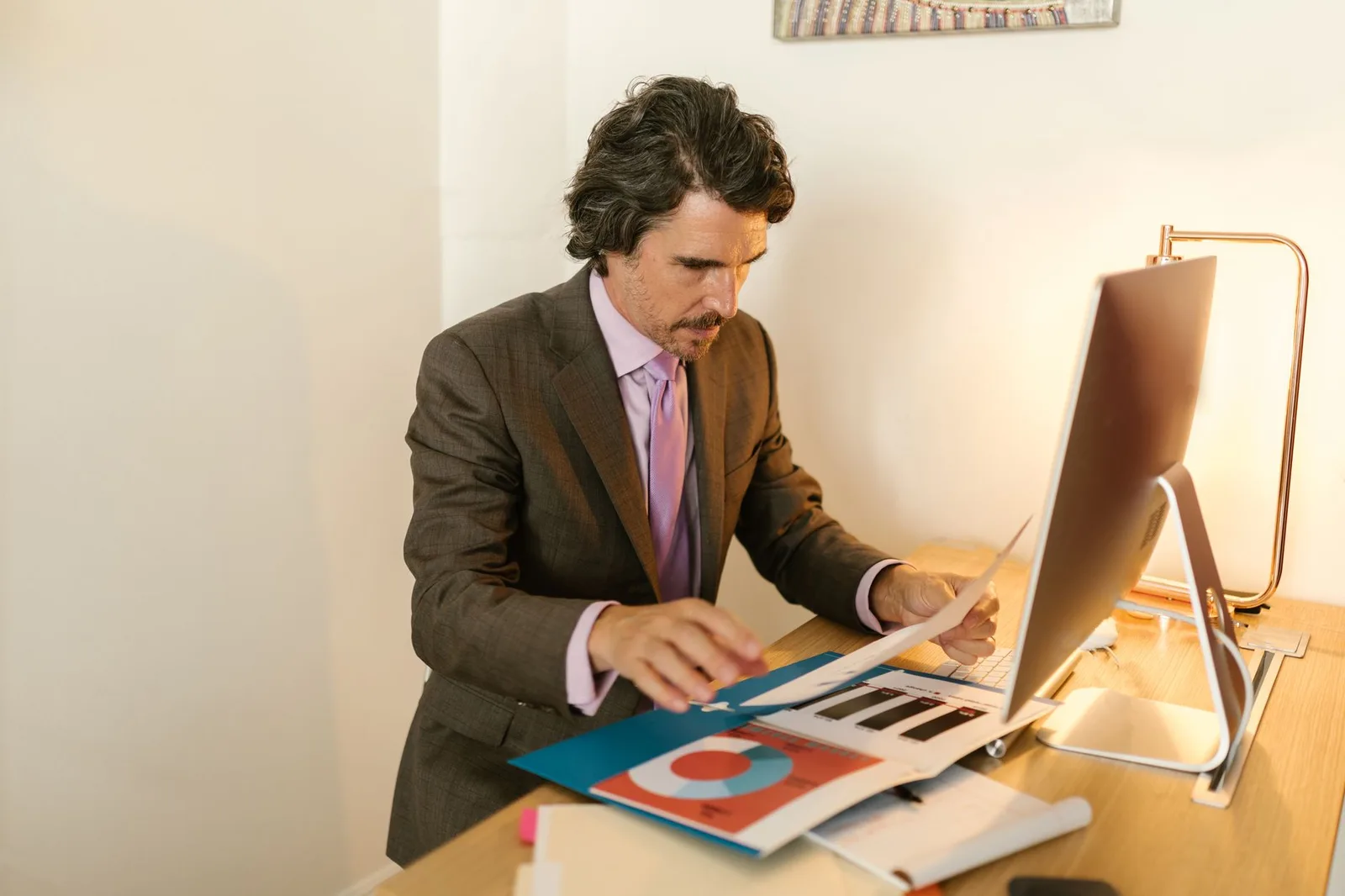 A nonprofit financial manager organizing annual giving statements and tax receipts at a desk