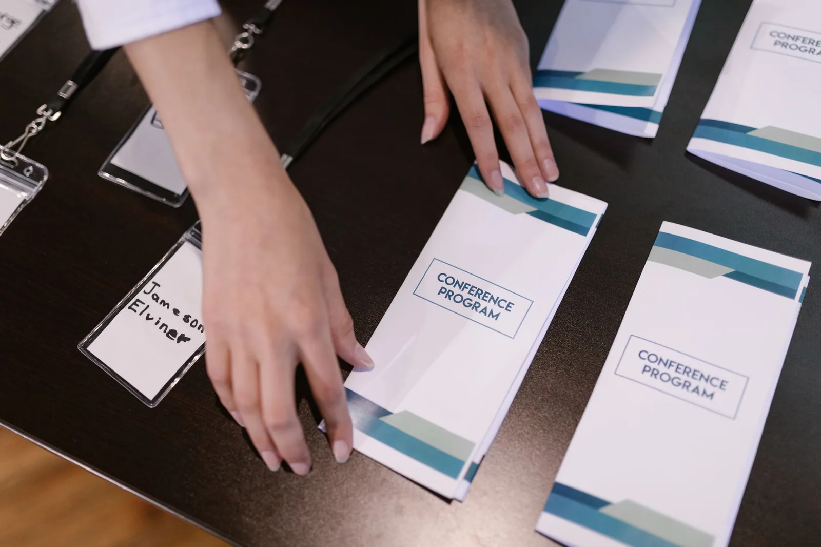 A small nonprofit team meeting with a local business sponsor at a table with event materials and a laptop.