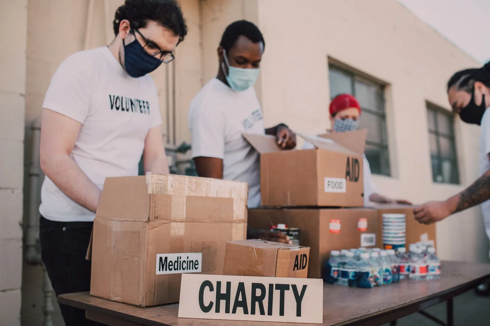 A small nonprofit team member reviewing donation settings on a laptop while another volunteer looks on