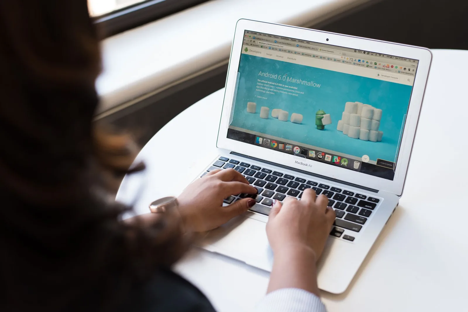 A nonprofit staff member reviewing a donation page on a laptop in a bright office setting.