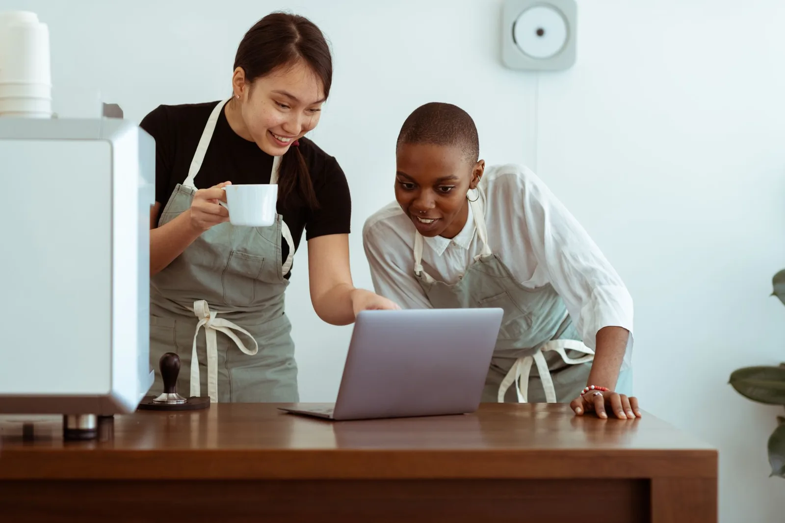 Two nonprofit staff members reviewing donor records on a laptop at a table
