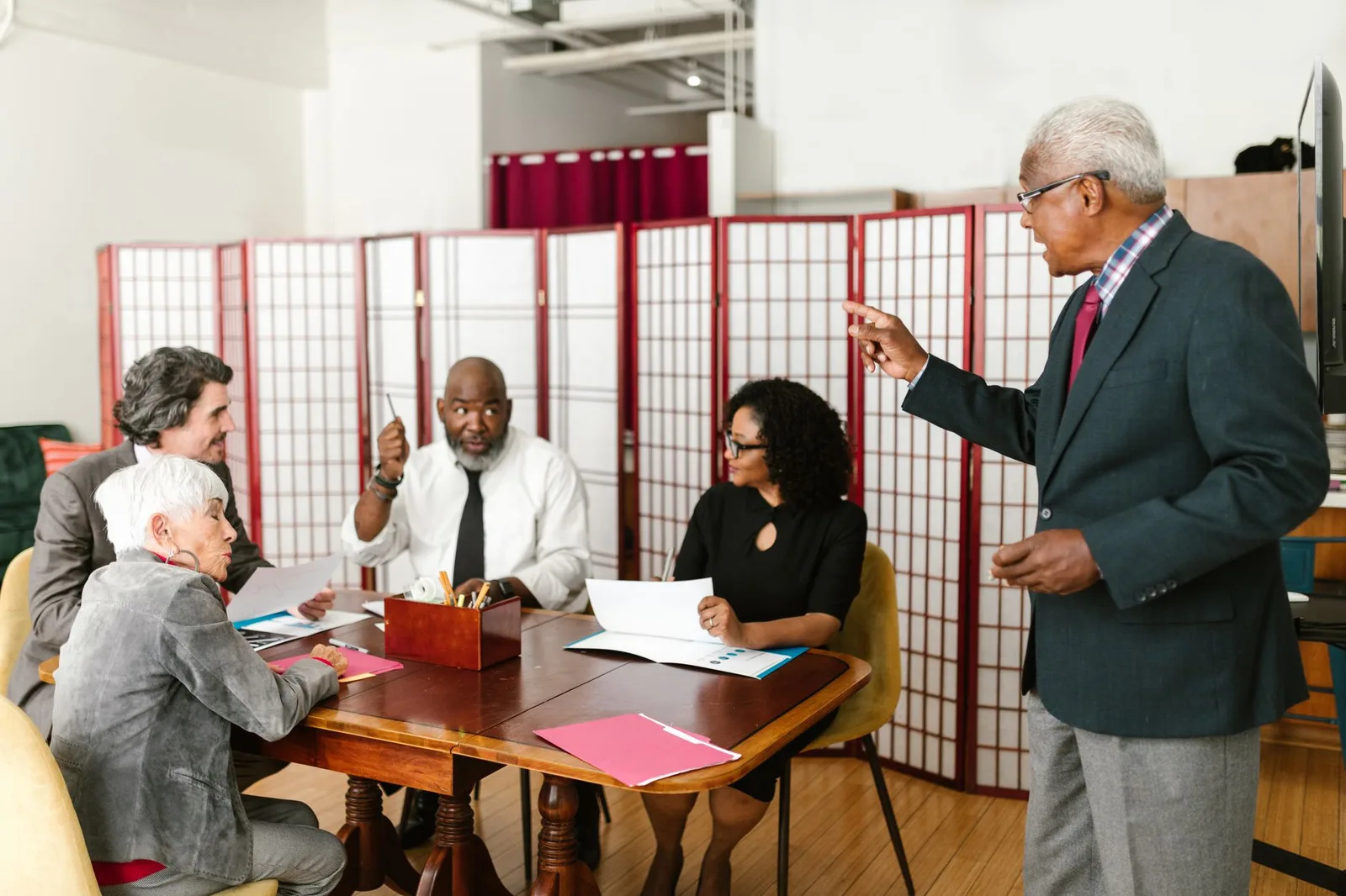 Two nonprofit staff members talking with a donor at a table in a community setting