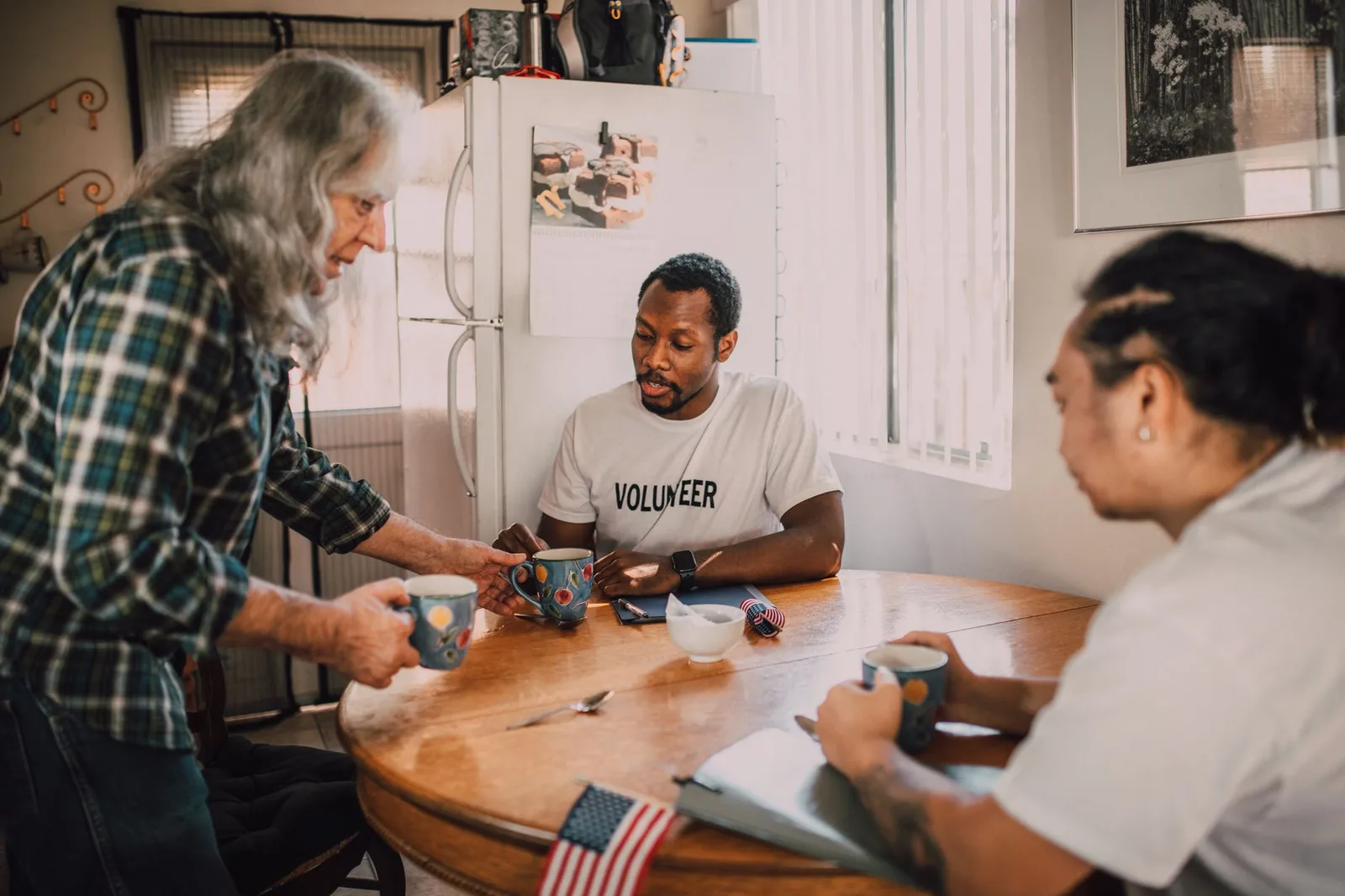 A diverse group of nonprofit team members collaborating around a meeting table in a bright community space.