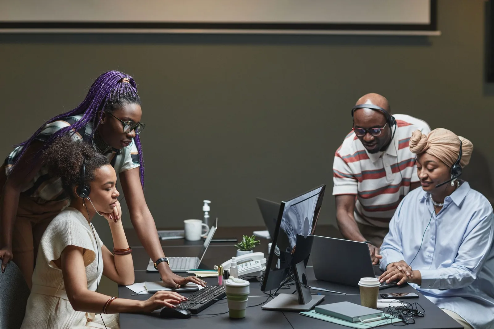 Nonprofit staff members reviewing monthly donation reports on a computer screen in a bright office environment.