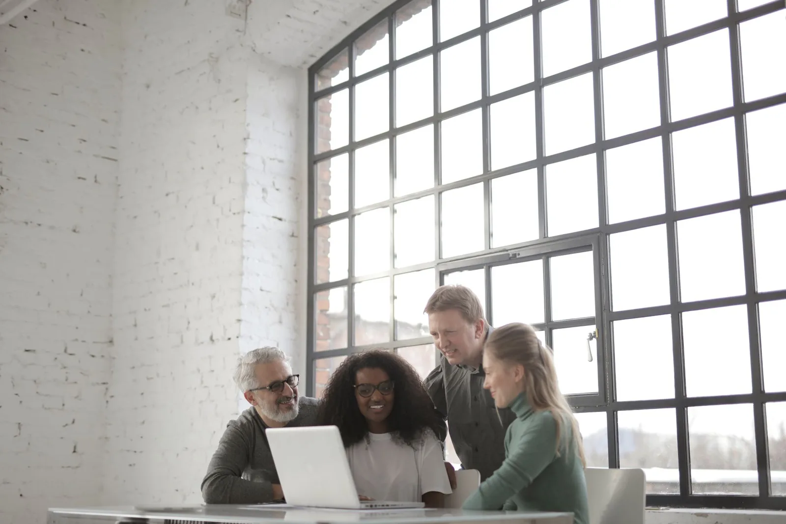 A small nonprofit team reviewing grant application answers together at a laptop