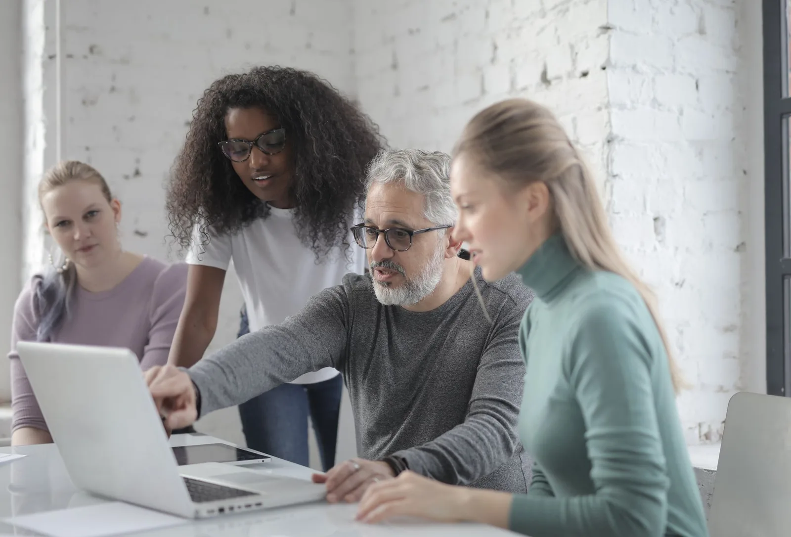 Small nonprofit team reviewing fundraising vendor documents on a laptop in an office setting