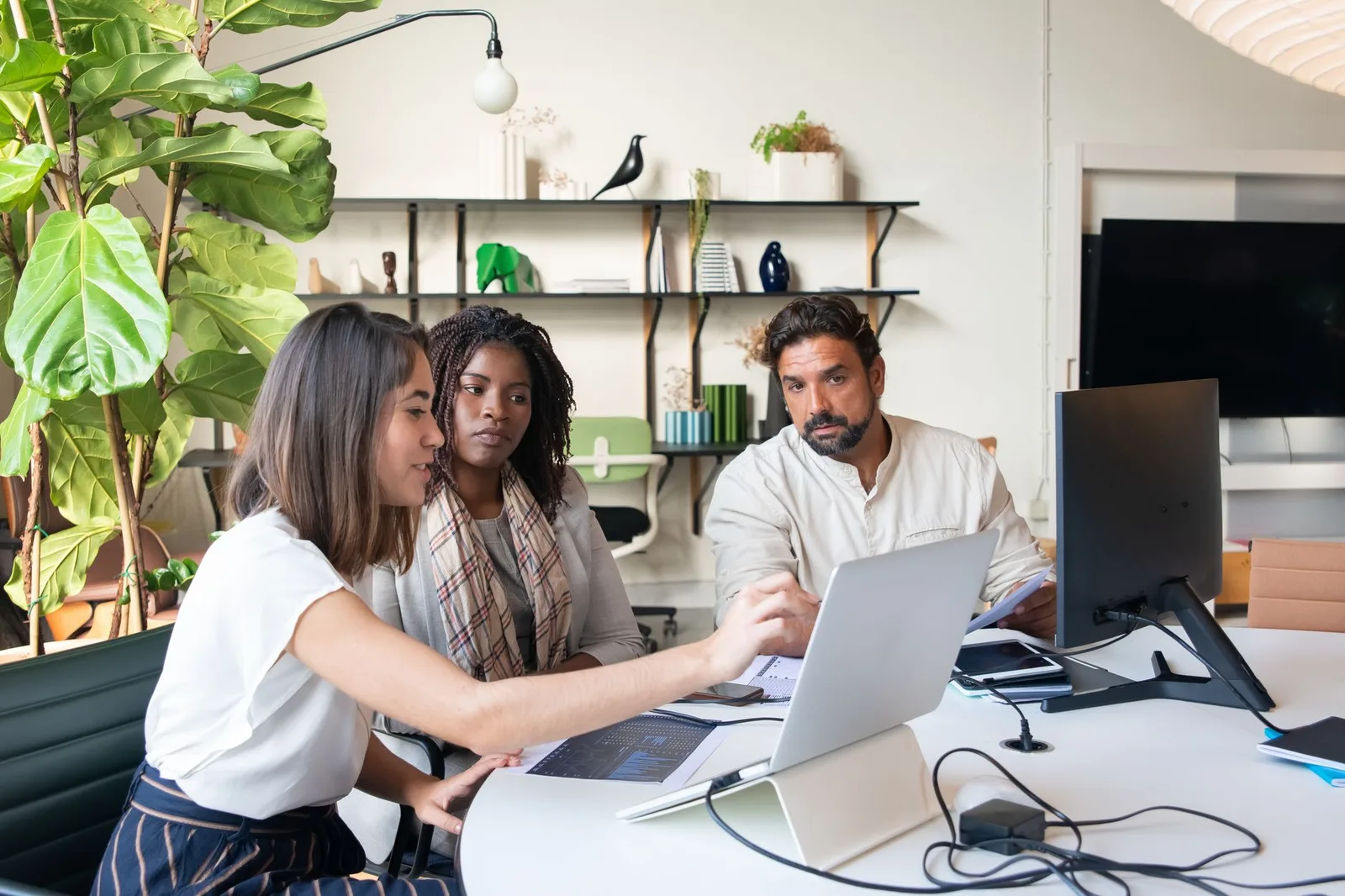 Two nonprofit staff members reviewing fundraising data on a laptop in an office setting.